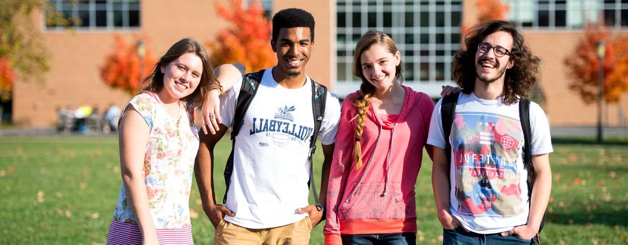 Diverse group of students stands among fall leaves